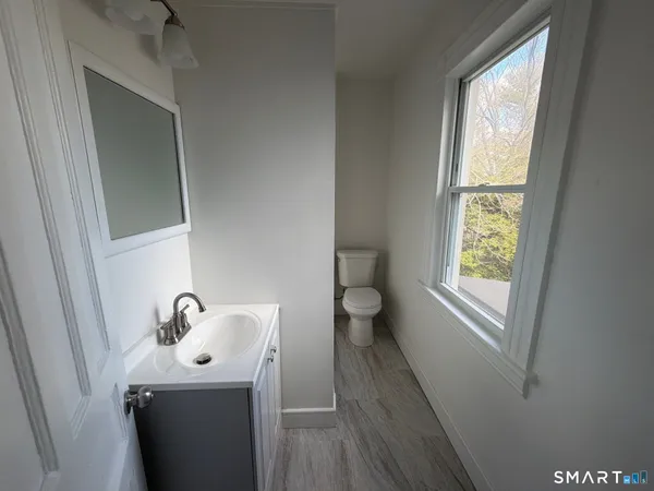 a bathroom with a toilet sink and mirror