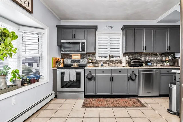 a kitchen with granite countertop a stove a sink and a refrigerator