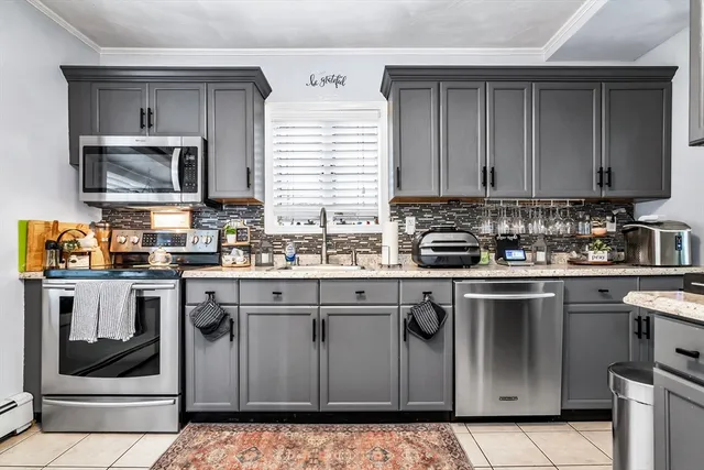 a kitchen with granite countertop a sink stove and microwave
