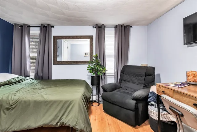 a bedroom with a bed window and a flat screen tv