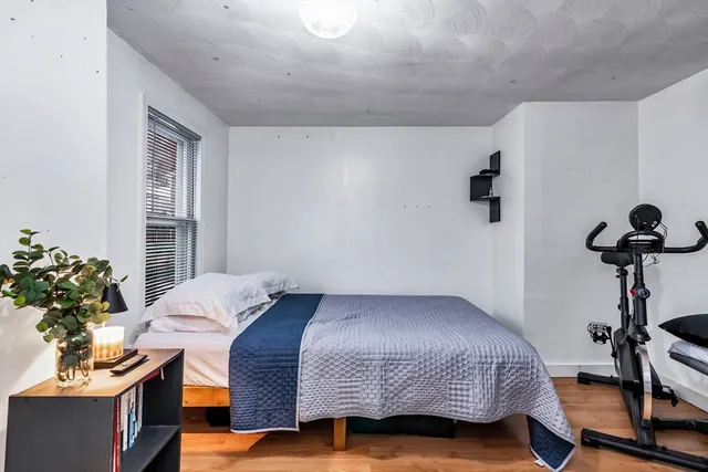 a bedroom with a bed and a potted plant