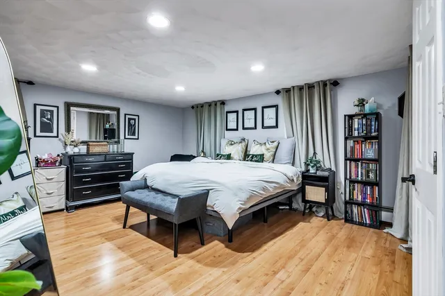a spacious bedroom with a bed a dresser and a book shelf
