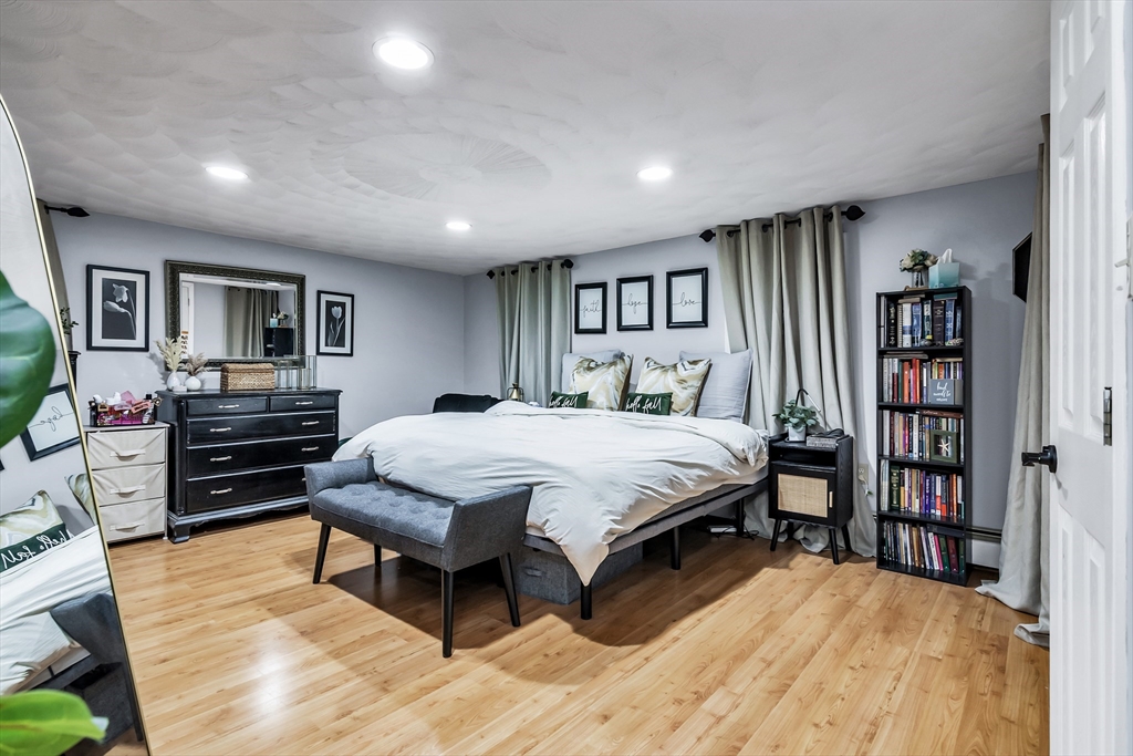 2 Maurice Avenue Lawrence, MA 01841 - Photo 24 of 36 a spacious bedroom with a bed a dresser and a book shelf