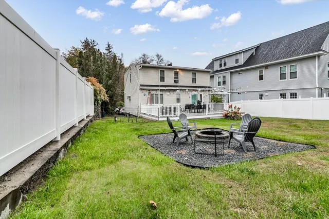 a view of a backyard with table and chairs potted plants and a palm tree