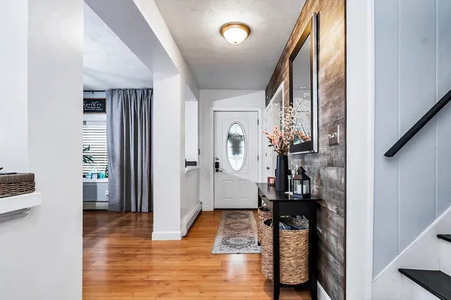 a view of hallway with wooden floor and furniture