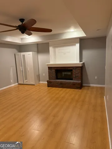 a view of an empty room with a fireplace and a window