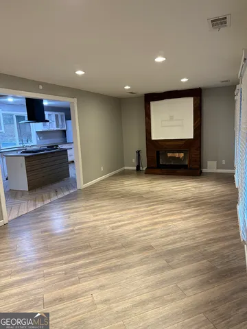 a view of room with wooden floor and kitchen