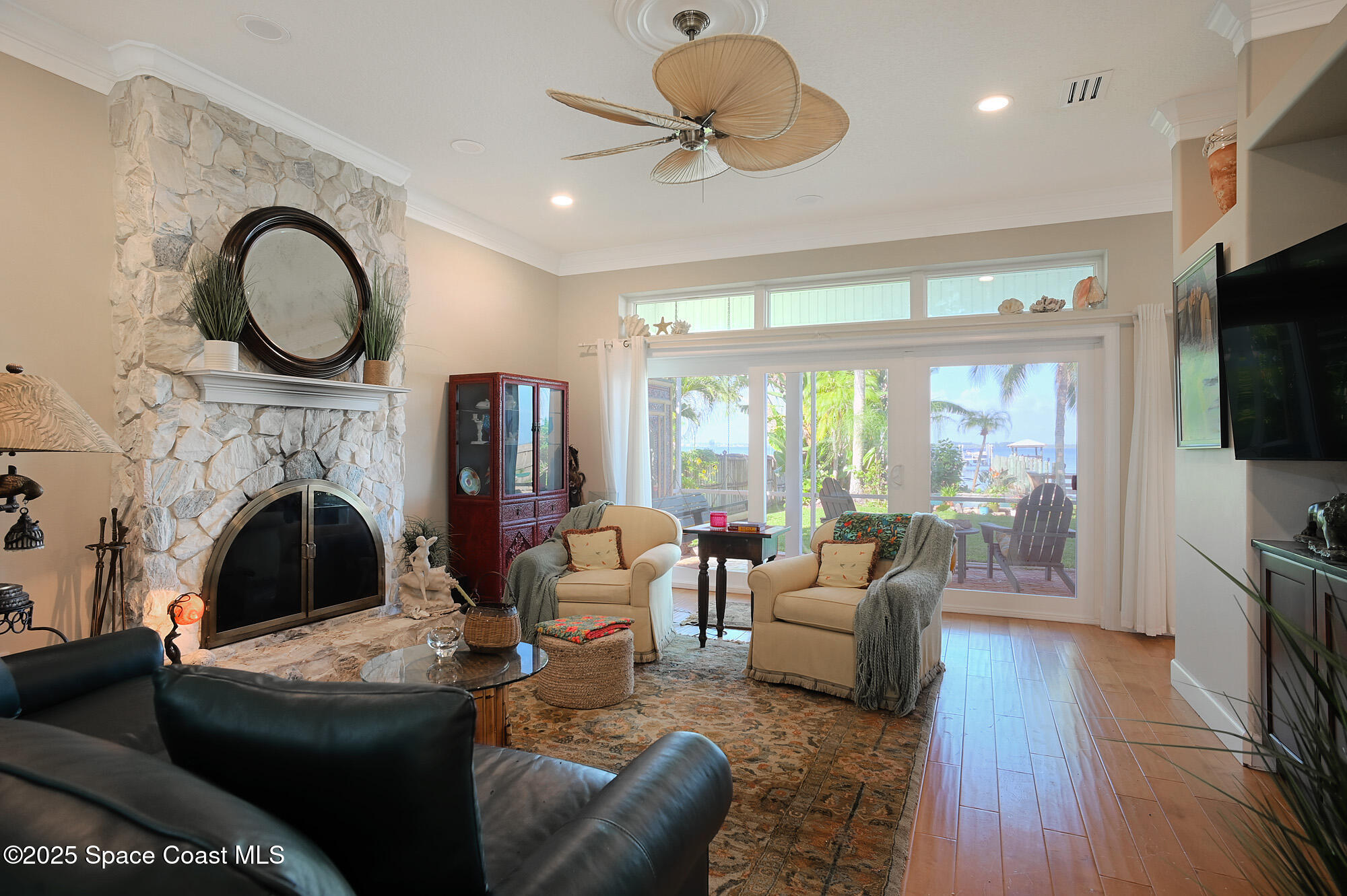 5930 Riverside Drive Melbourne Beach, FL 32951 - Photo 16 of 46 a living room with furniture a flat screen tv and a fireplace