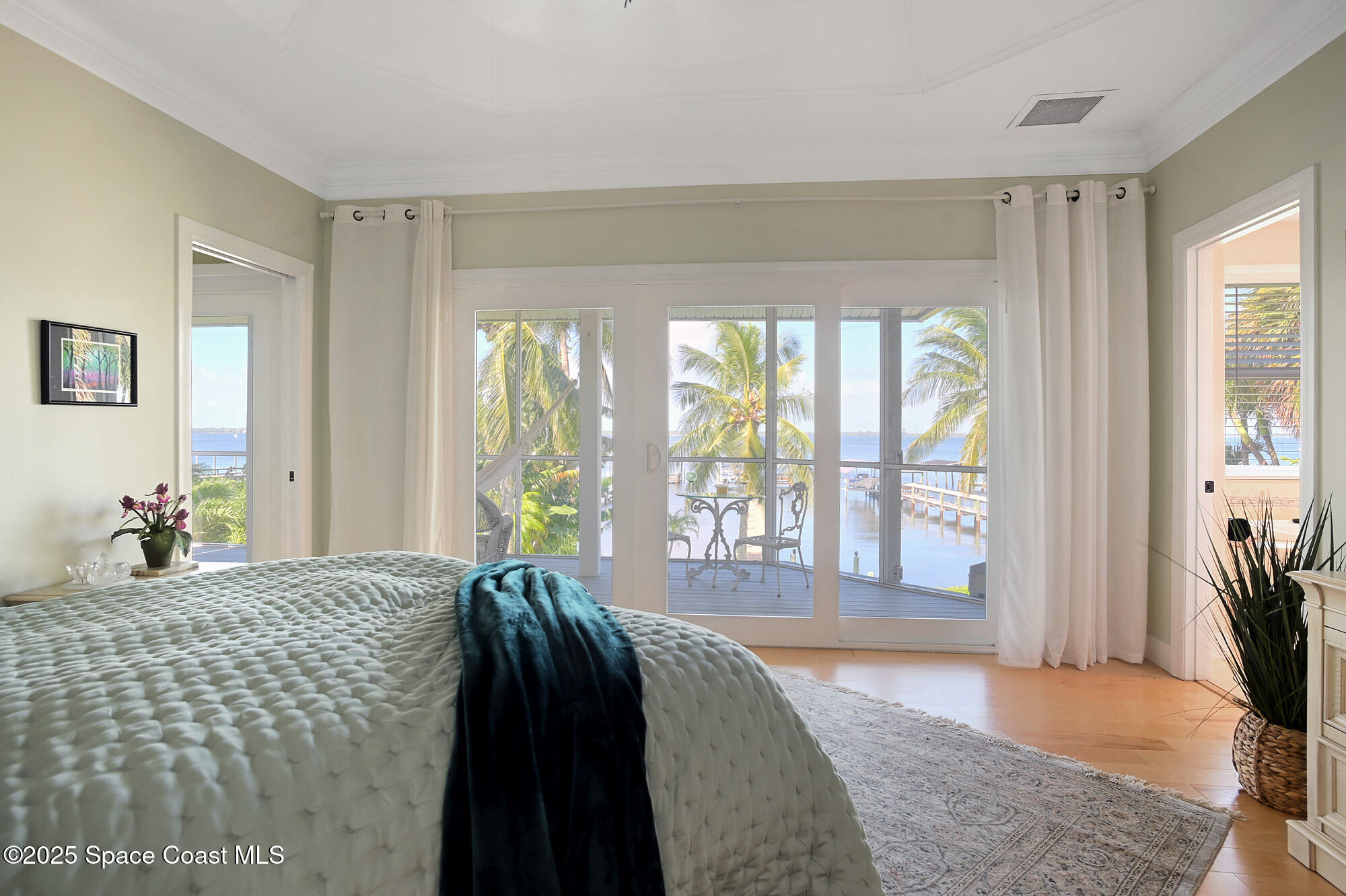 5930 Riverside Drive Melbourne Beach, FL 32951 - Photo 19 of 46 a spacious bedroom with a bed and a large window