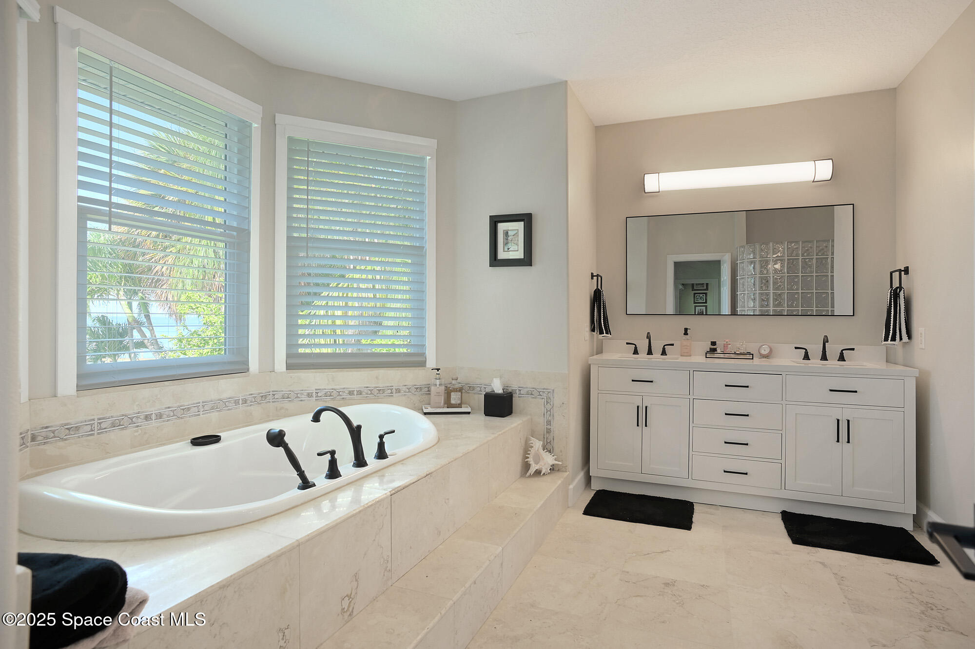 5930 Riverside Drive Melbourne Beach, FL 32951 - Photo 22 of 46 a spacious bathroom with sinks mirror and a bathtub
