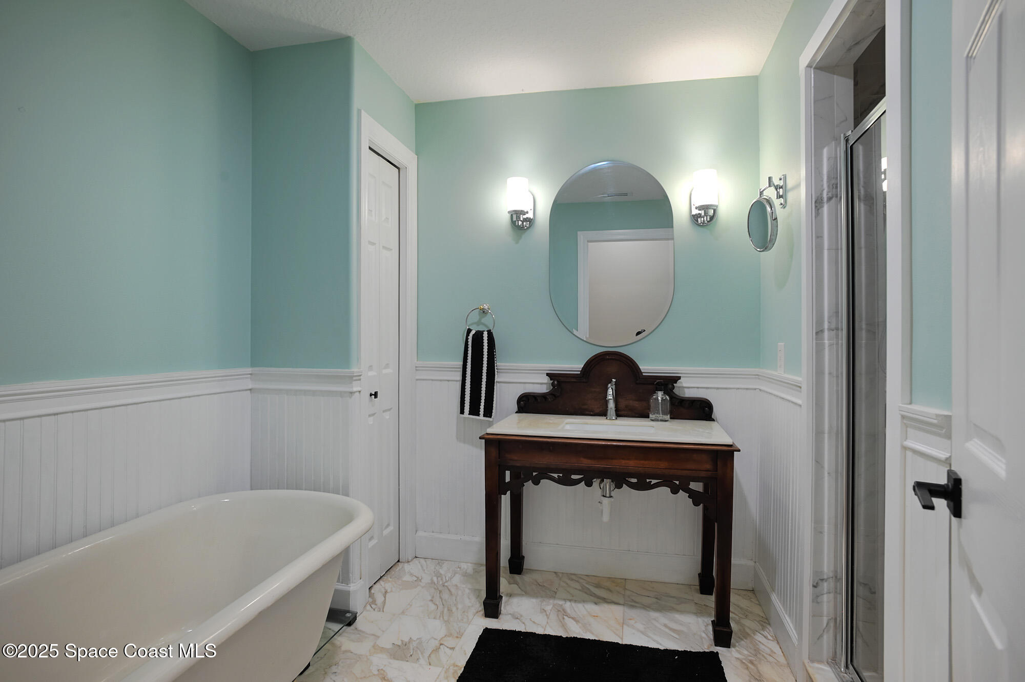 5930 Riverside Drive Melbourne Beach, FL 32951 - Photo 25 of 46 a bathroom with a sink a mirror and a bathtub