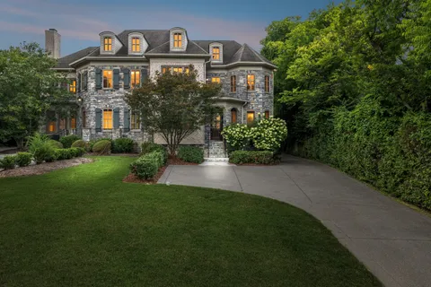 a front view of a house with a yard and potted plants