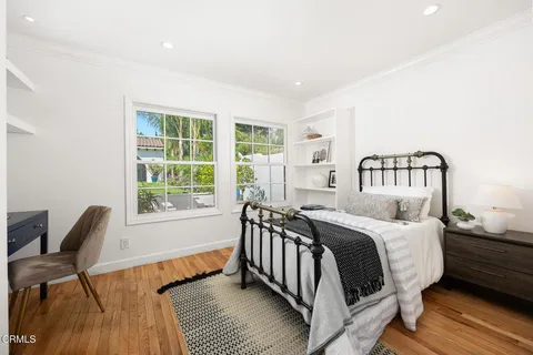 a bedroom with a bed and wooden floor