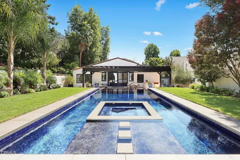 a front view of house with yard swimming pool and green space