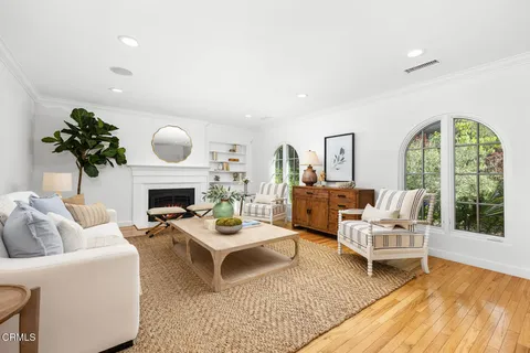 a living room with furniture a fireplace and a floor to ceiling window