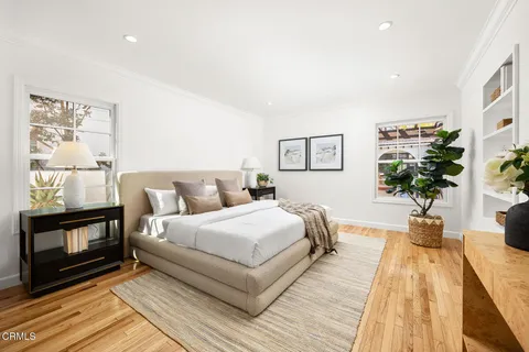 a bedroom with a large bed and a potted plant on dresser