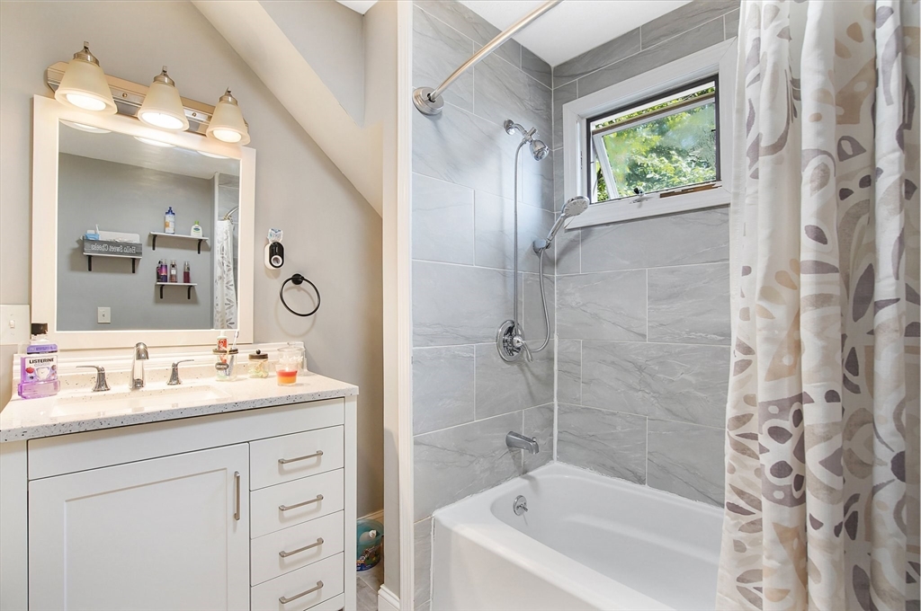 15 Eldert Street Springfield, MA 01109 - Photo 13 of 28 a bathroom with a bathtub sink vanity and mirror