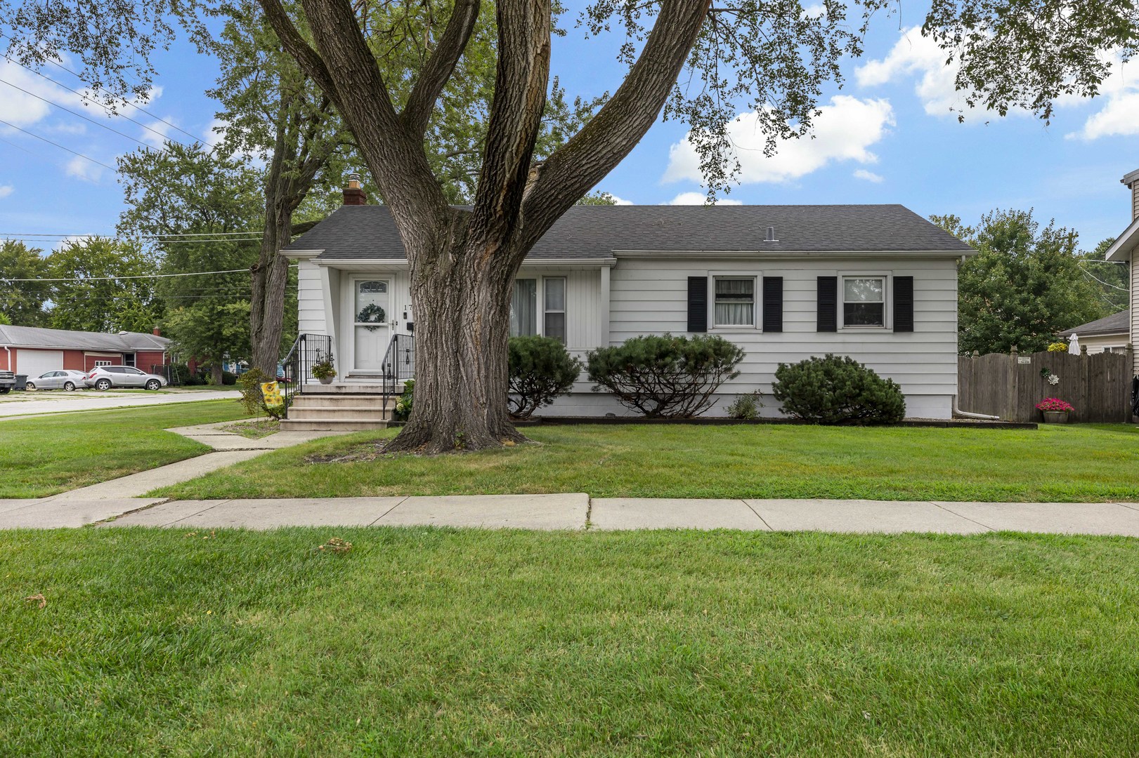 17905 Ridgewood Avenue Lansing, IL 60438 - Photo 2 of 18 a front view of a house with a yard and trees
