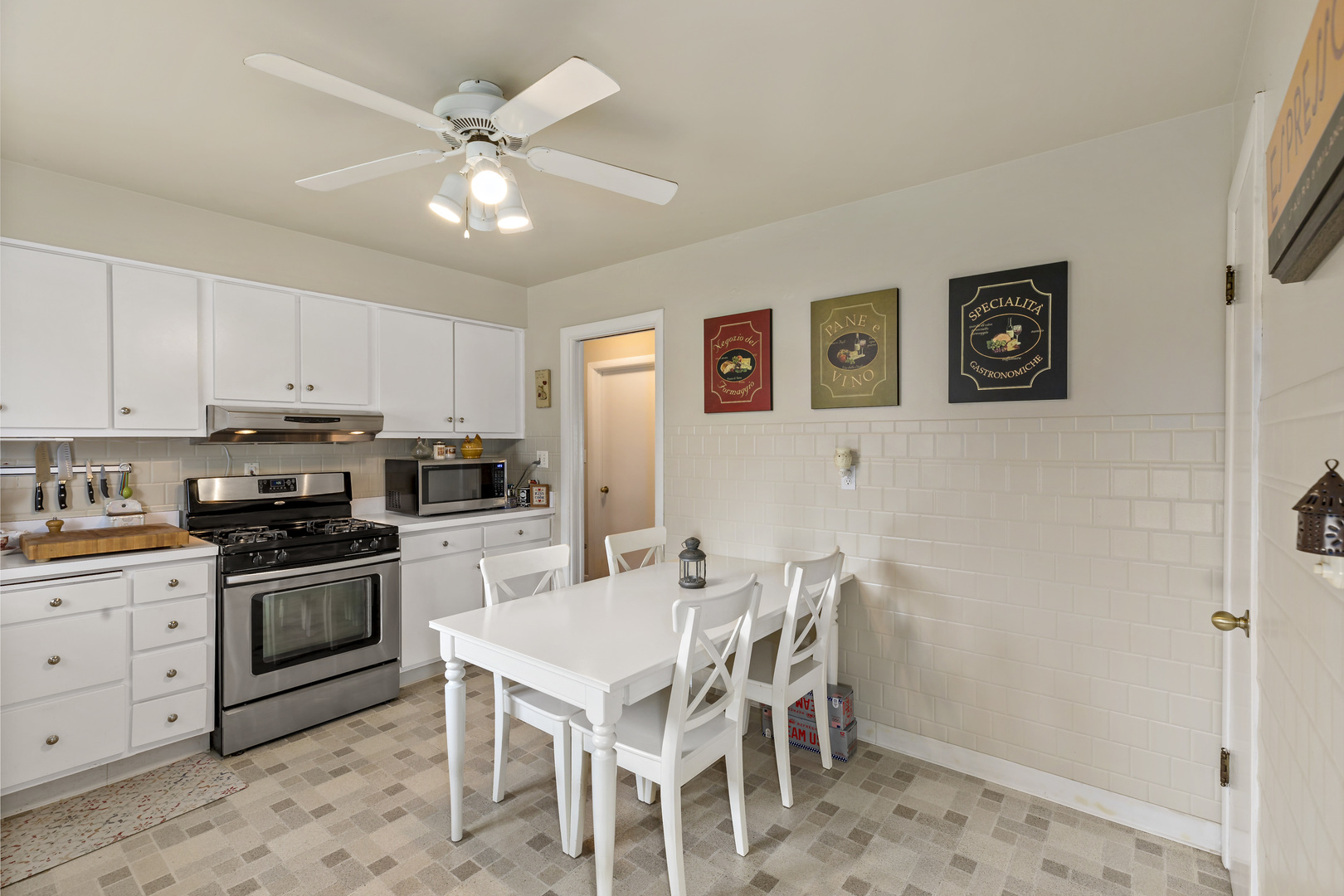 17905 Ridgewood Avenue Lansing, IL 60438 - Photo 9 of 18 a white kitchen with a stove a sink a dining table and chairs