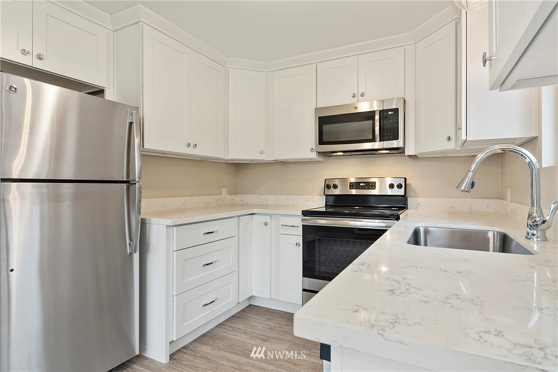 742 North 92nd Street Seattle, WA 98103 - Photo 11 of 16 a kitchen with white cabinets and refrigerator