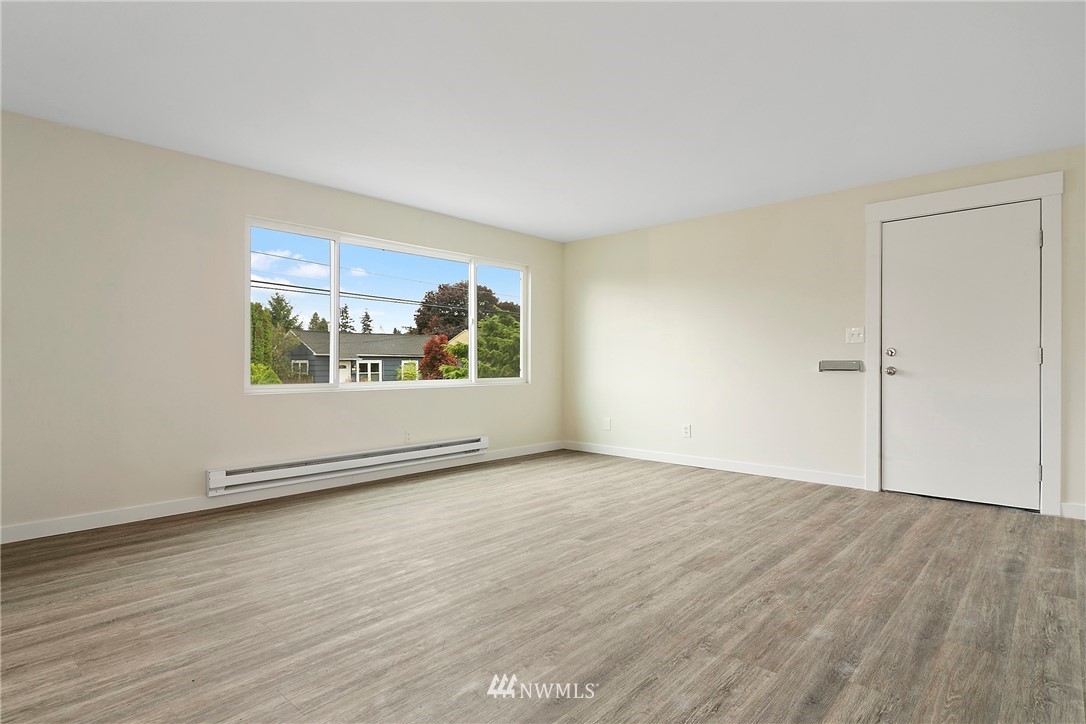 742 North 92nd Street Seattle, WA 98103 - Photo 9 of 16 an empty room with wooden floor cabinet and windows