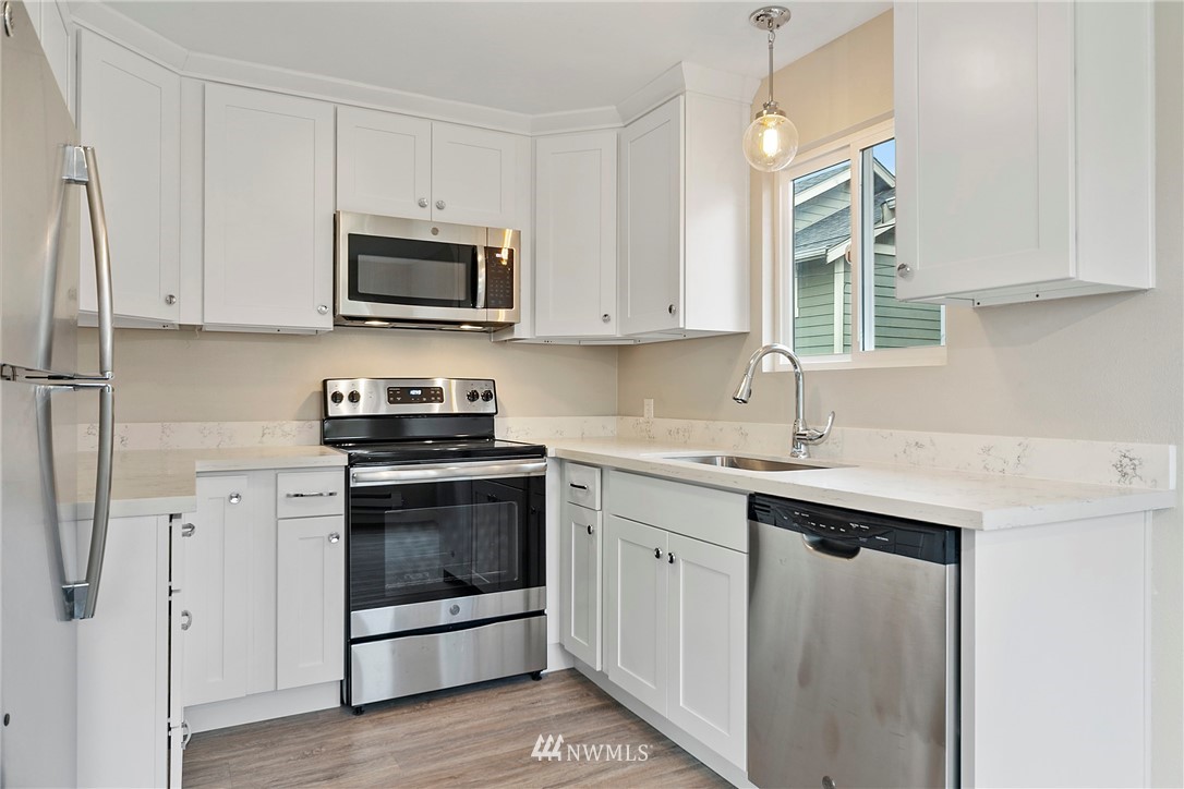 742 North 92nd Street Seattle, WA 98103 - Photo 10 of 16 a kitchen with stainless steel appliances granite countertop a sink stove and microwave