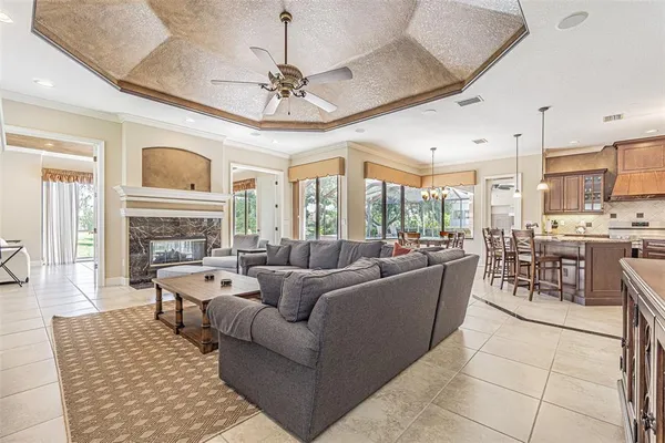 a living room with furniture a fireplace and a chandelier