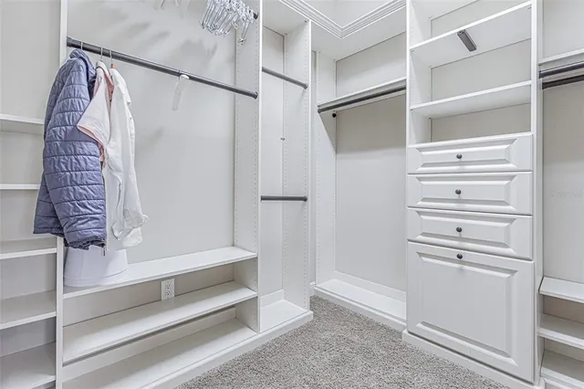 a view of walk in closet with clothes and shoes