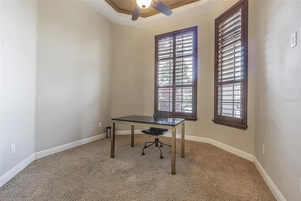 a view of a workspace with furniture and a window