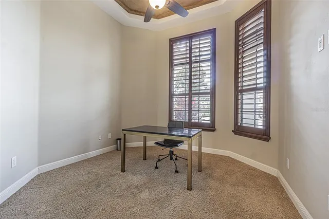 a view of a workspace with furniture and a window