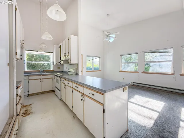 a kitchen with granite countertop a stove a sink and a window