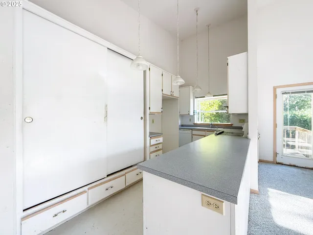 a view of a kitchen with a fridge and wooden floor