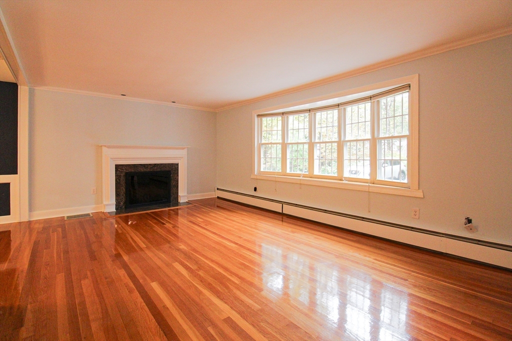 1116 George Hill Road Lancaster, MA 01523 - Photo 10 of 37 a view of an empty room with wooden floor and a window