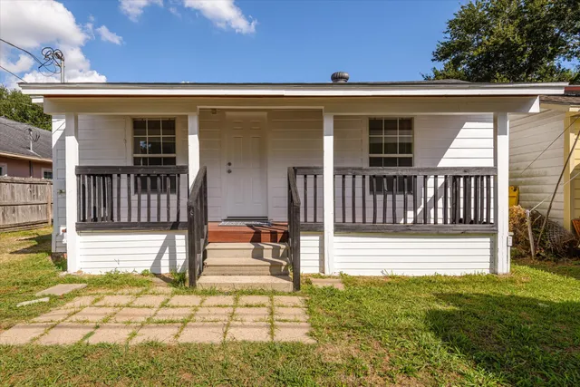 a view of a house with backyard and deck