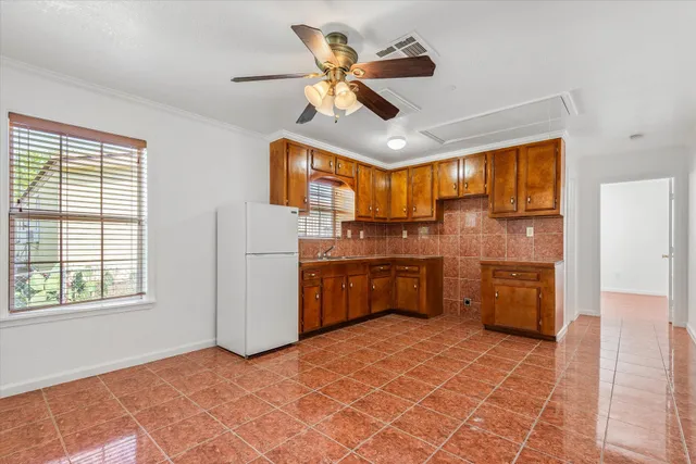 a kitchen with a stove a refrigerator and cabinets