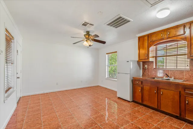 a view of a kitchen with a sink cabinet and windows