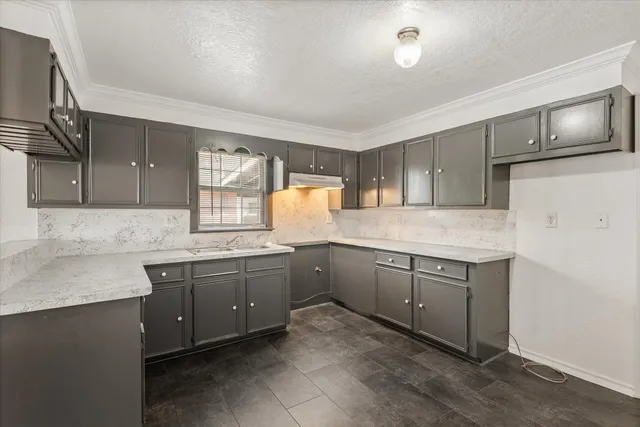 a kitchen with granite countertop cabinets stainless steel appliances a sink and a window