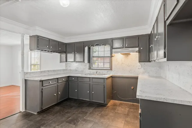 a kitchen with granite countertop a sink and cabinets