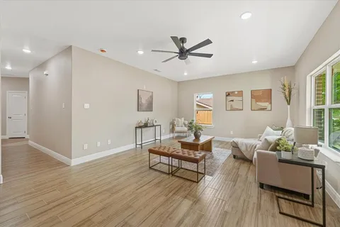a living room with furniture and a wooden floor