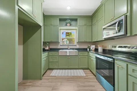a kitchen with a sink cabinets and wooden floor