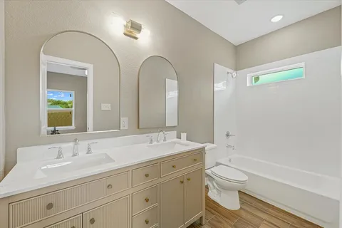 a bathroom with a double vanity sink a toilet and a mirror