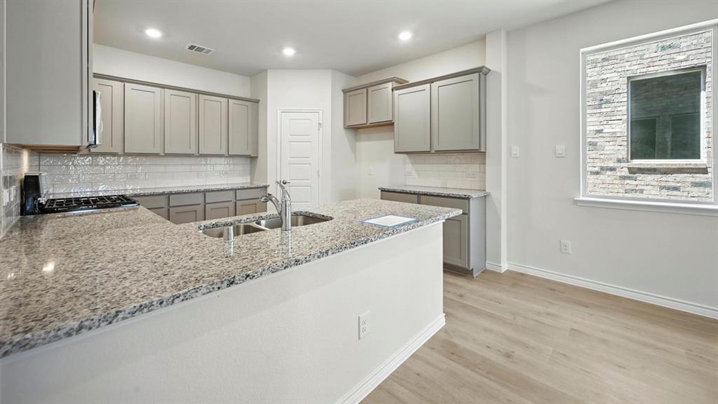 3516 Ample Vista Road Aubrey, TX 76227 - Photo 25 of 36 a kitchen with stainless steel appliances granite countertop a sink a stove a refrigerator and cabinets