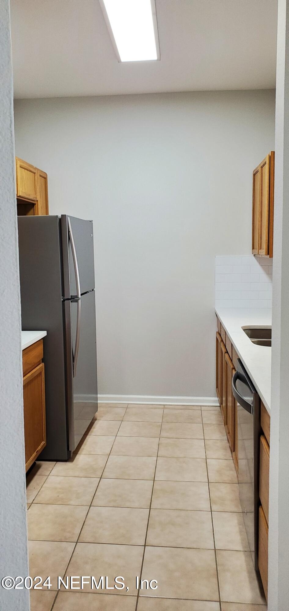 10550 Baymeadows Road, Unit 1012 Jacksonville, FL 32256 - Photo 3 of 18 a kitchen with granite countertop a refrigerator and a stove top oven
