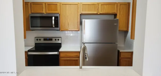 a kitchen with stainless steel appliances a refrigerator and a microwave