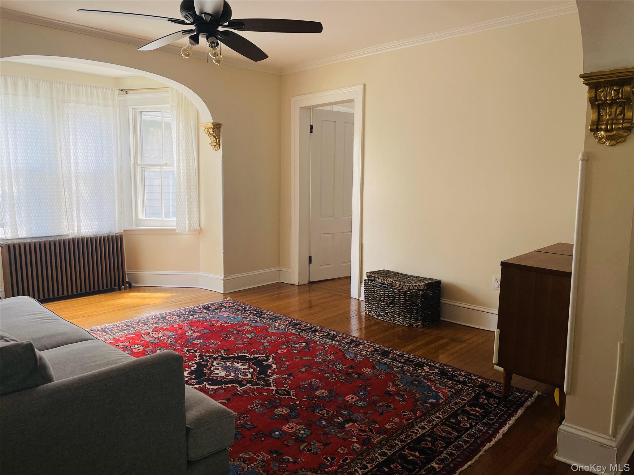 12 Parrott Street Cold Spring, NY 10516 - Photo 6 of 18 Living area featuring ceiling fan, arched walkways, wood finished floors, baseboards
