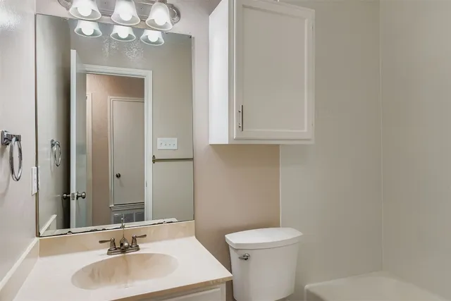 a bathroom with a sink a toilet and mirror