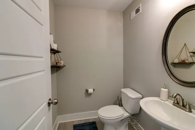 a bathroom with a granite countertop toilet sink and mirror