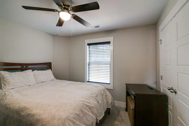 a bedroom with a bed and a ceiling fan