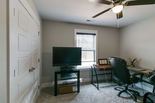 a view of a workspace with furniture and a window