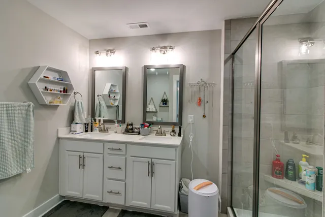 a bathroom with a double vanity sink mirror and toilet